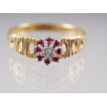 A yellow metal dress ring, stamped 18ct, cluster set diamond and rubies, size U