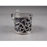 A Victorian silver mustard pot with pierced and scrolled decoration, and blue glass liner, 3.2oz