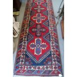 A pair of Kazak wool runners with ten central medallions, in shades of red, blue and natural, 35"