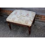 A mahogany centre stool of Regency design with brocade seat, on turned reeded and castored supports
