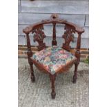 A 19th century carved mahogany corner elbow chair with griffin splats and drop-in seat, on turned