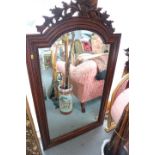 A carved hardwood framed wall mirror with arch top bevelled plate and pierced scroll crest, 57" x
