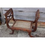 An Anglo-Indian carved hardwood window seat of Regency design with cane seat, on reeded sabre