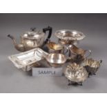 An assortment of silver plate, including a three-piece teaset, wine coasters and other items