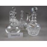 Seven clear cut glass decanters, a claret jug with pewter mounts and another jug