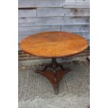 An early 19th century pollard oak single-piece circular tilt top table, on vase turned mahogany