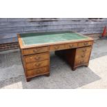 A partners walnut double pedestal desk with green tooled leather lined top, fitted cupboards and