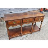 An oak dresser base, fitted three drawers, 54 1/2" wide x 18 1/2" deep x 30" high