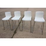 A set of four chrome frame high seat stools with white acrylic seats