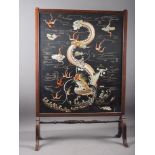 *An early 20th century mahogany framed firescreen with dragon embroidered silk panel, 23 1/2" wide x