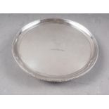 A silver circular shaped card tray with engraved ostrich motif and gadrooned border, on ball and