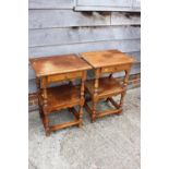 A pair of oak two-tier side/lamp tables, fitted one drawer, on turned and stretchered supports,