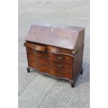 An early 19th century Italian walnut and banded serpentine front bureau with fitted interior over