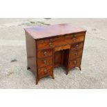 A George III figured mahogany, ebony line inlaid and banded knee hole desk, fitted adjustable