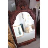 A carved hardwood framed wall mirror with shell crest and bevelled plate, 48" x 26" overall