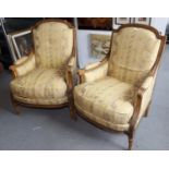 A pair of Regency Revival armchairs with carved giltwood showframes, upholstered in a floral figured