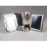 Two white metal photograph frames, stamped 925, a silver photograph frame, a trophy, a silver napkin