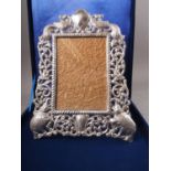 An Indian white metal easel photograph frame, decorated elephants and peacocks, stamped silver, in