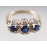 An 18ct gold three-stone sapphire and diamond ring, size G, 3.7g