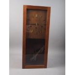 A mid century teak cased drop dial wall clock with gilt baton numerals, 24" high