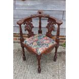 A 19th century carved mahogany corner elbow chair with griffin splats and drop-in seat, on turned