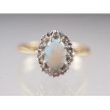 An 18ct gold, platinum, opal and diamond cluster ring, size I, 2.9g