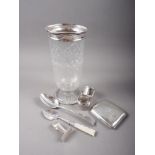 A cut glass and silver topped celery vase, a cigarette case, a dessert spoon, two silver napkin