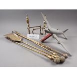 A set of brass fire irons, a painted model airplane, a brass adjustable fender curb, 47 1/4" wide,