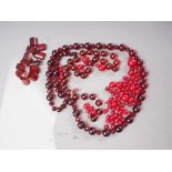A string of circular and faceted cherry amber Bakelite beads and a number of loose cherry amber