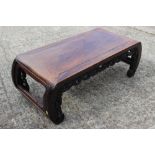 A Chinese carved hardwood low table, on scroll end supports, 37" long x 16 1/2" deep x 12 1/2" high