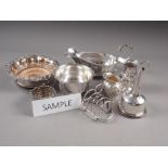 A pair of silver plated bottle stands with grape and vine decoration, a bottle coaster with turned