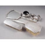 A three-piece silver backed dressing table set, two silver napkin rings, a salt cellar and a salt