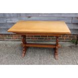 A light oak refectory table, on pierced panel end stretchered supports, 48" long x 30" wide x 29"