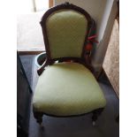 A Victorian carved walnut low seat occasional chair, upholstered in a green fabric