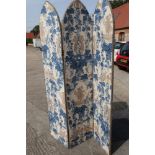 A three-fold arch top room divider, upholstered in a blue and white grape and vine fabric, 48"