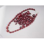 A cherry amber Bakelite graduated bead necklace, the largest oval bead 5mm wide, and a number of