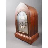 An Edwardian mahogany and line inlaid arch topped mantel clock with silvered dial and Roman