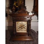 A Junghans mahogany cased mantle clock with tower finial, swags and half bobbin turned columns and
