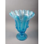 A blue glass pedestal vase with shaped flared rim and applied decoration, 14 1/2" high