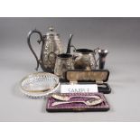 A silver plated three-piece teaset with embossed decoration, a pair of plated sandwich servers, in