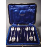 A cased set of six silver teaspoons and matching sugar tongs with bright cut decoration, 3.2oz