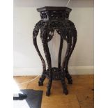 A Chinese carved hardwood hexagonal topped plant stand, inset hardstone, on six carved cabriole