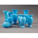 Three milk blue moulded glass vases with relief swag and sprig decoration, 5 1/4" high, a similar