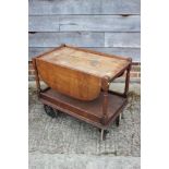 An early 20th century oak, two-tier flap top tea trolley, 28" wide x 16" deep x 25" high