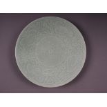 A Chinese celadon glazed plate with incised floral and scrolled decoration, 11 1/2" dia