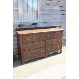 A late 18th century oak and mahogany ledge back sideboard with lift-up top, fitted three short