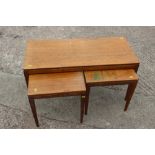 A nest of three 1960s teak tables, on square taper supports, largest 33" wide x 15" deep x 17 1/2"
