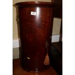 A mahogany bow fronted corner cupboard, enclosed two shelves, 24 1/2" high x 14 1/2" wide, and an