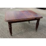 A Victorian walnut extending dining table with two extra leaves, on turned and carved castored