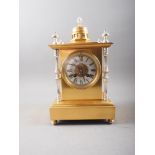 A gilt and silvered metal mantel clock with silvered dial and Roman numerals, 13" high